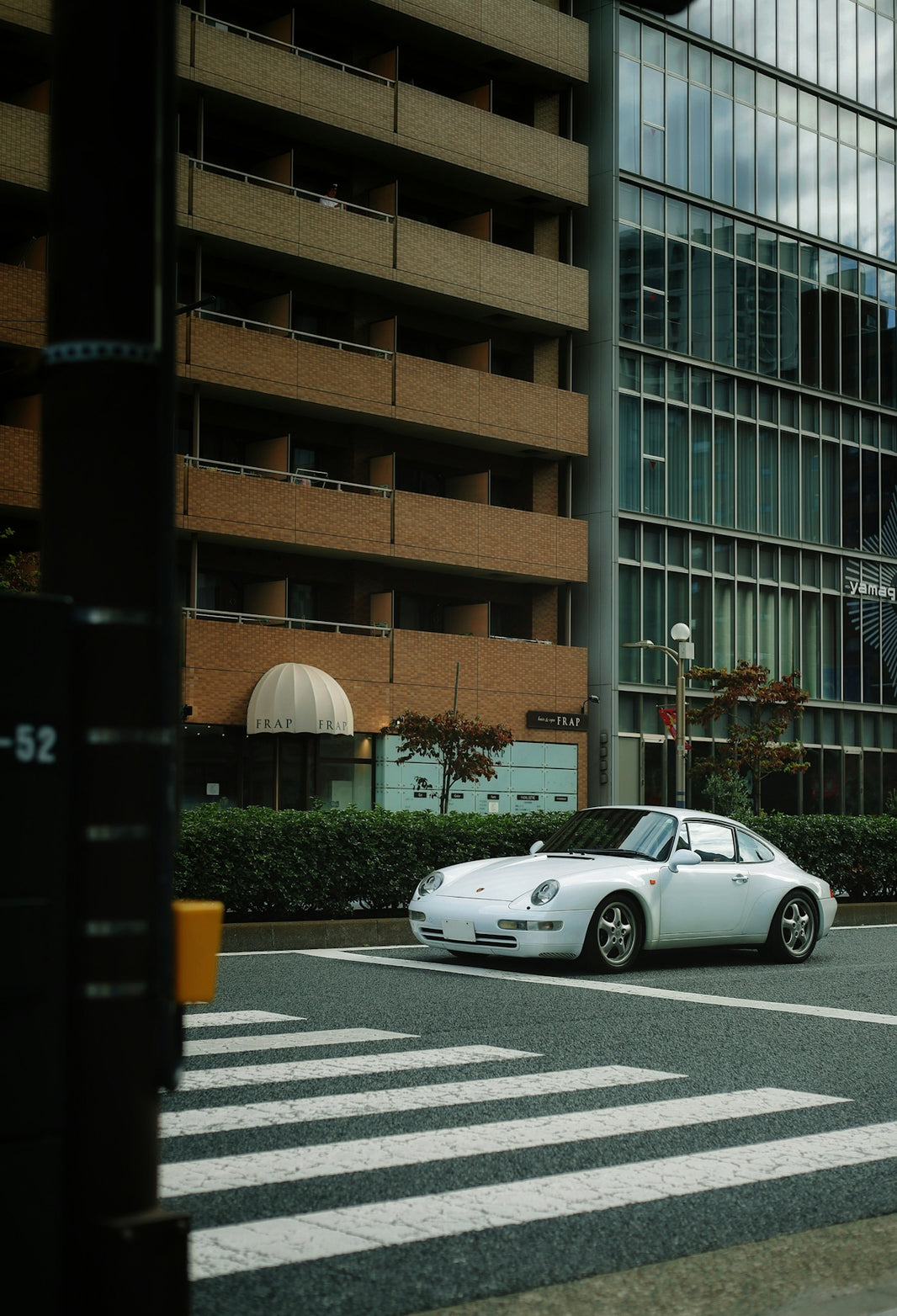 White porsche driving on a city street.
