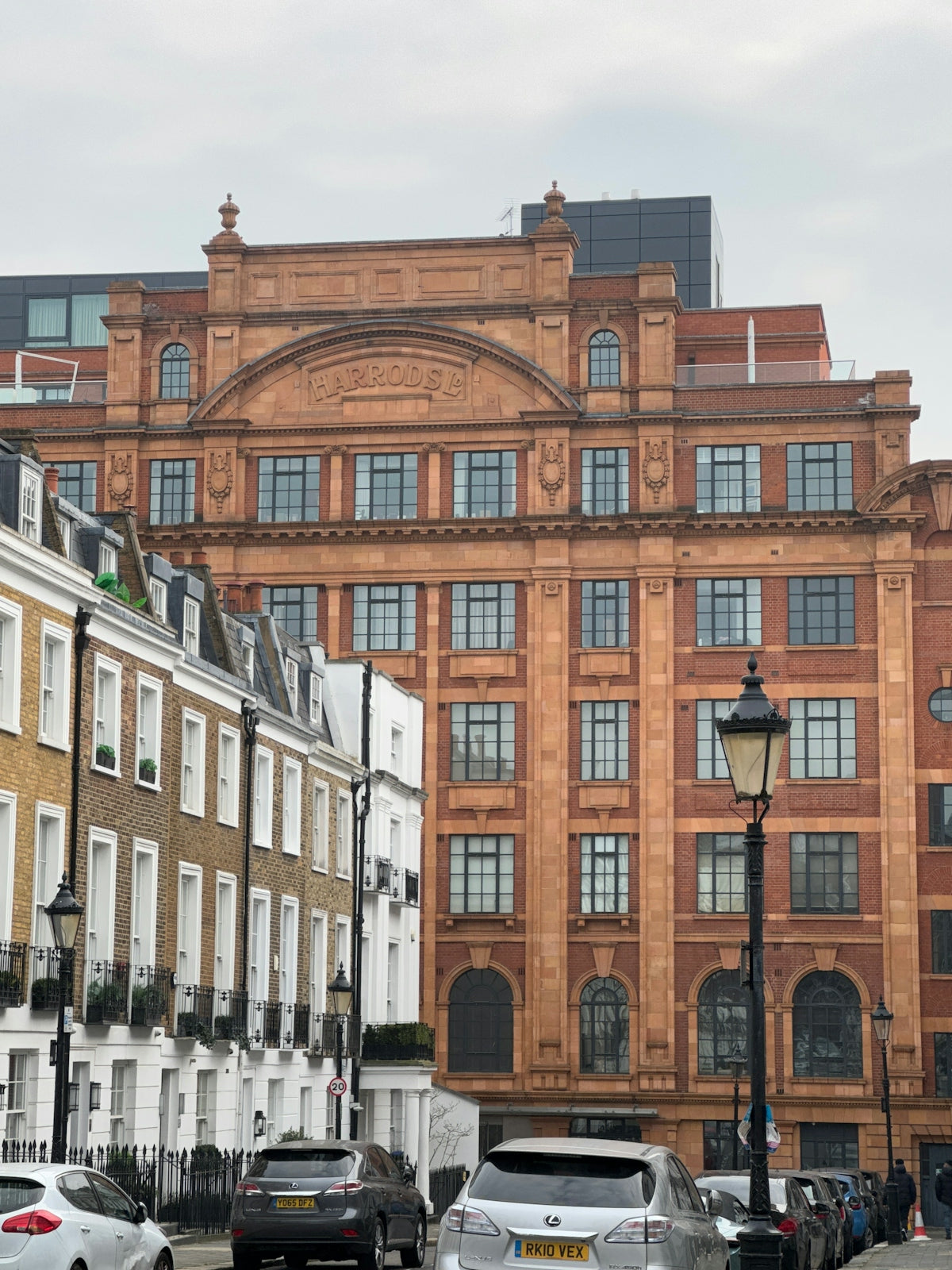 Terracotta building with ornate windows and cars.