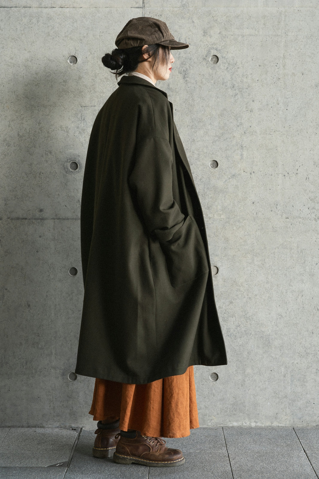 Woman in dark coat and orange skirt