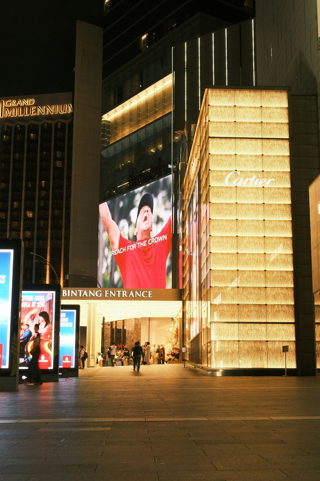 Nighttime cityscape with illuminated buildings and billboards