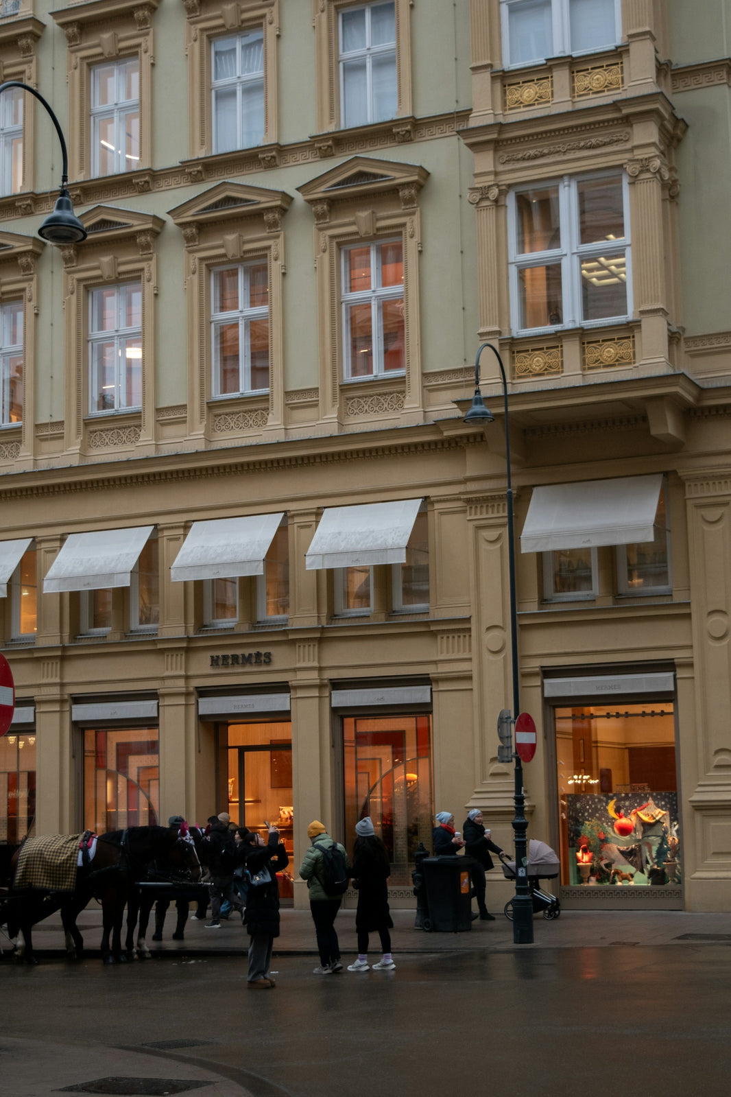 Hermes store facade with people and horse-drawn carriage