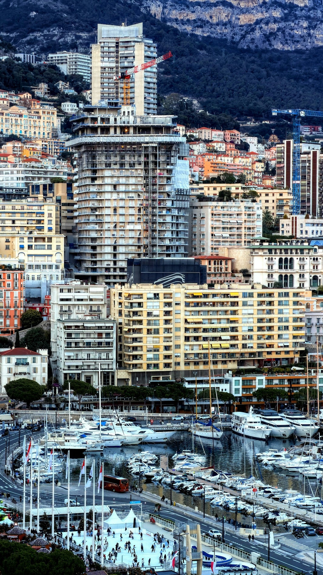 Boats docked in a harbor with city buildings behind.