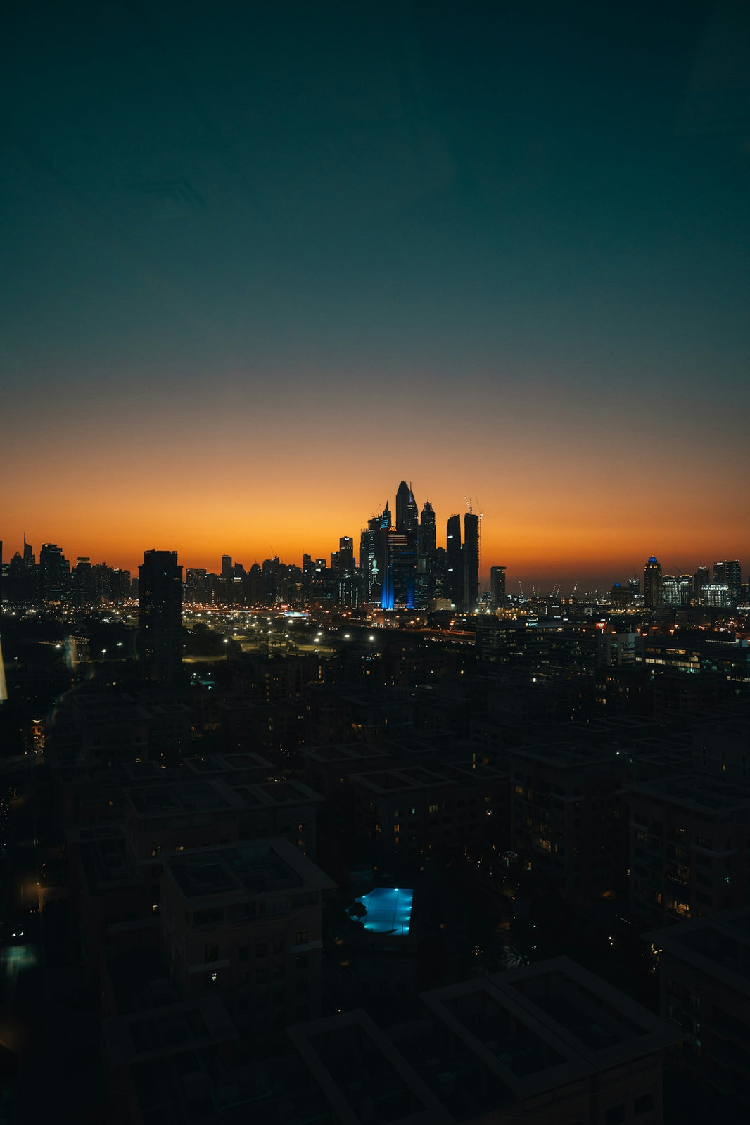 City skyline illuminated at dusk with colorful sky.