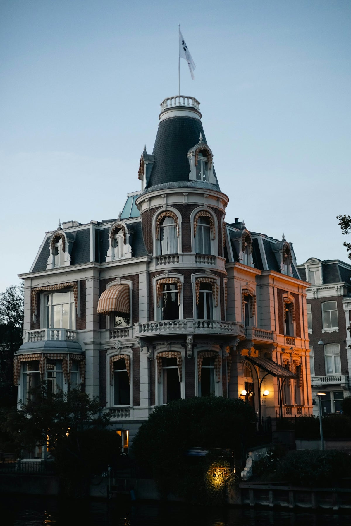 Ornate historic building with a mansard roof at dusk.