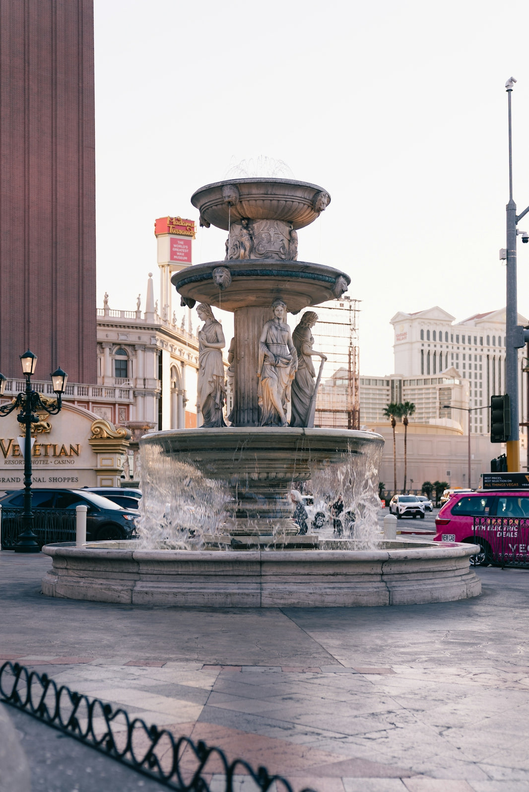 Ornate fountain with statues in a city square.