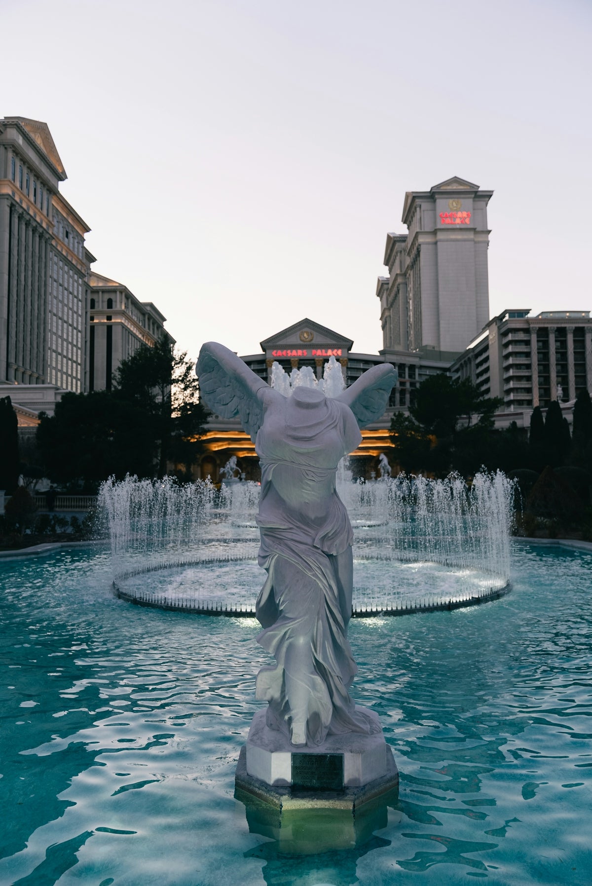 Statue in front of a fountain and buildings