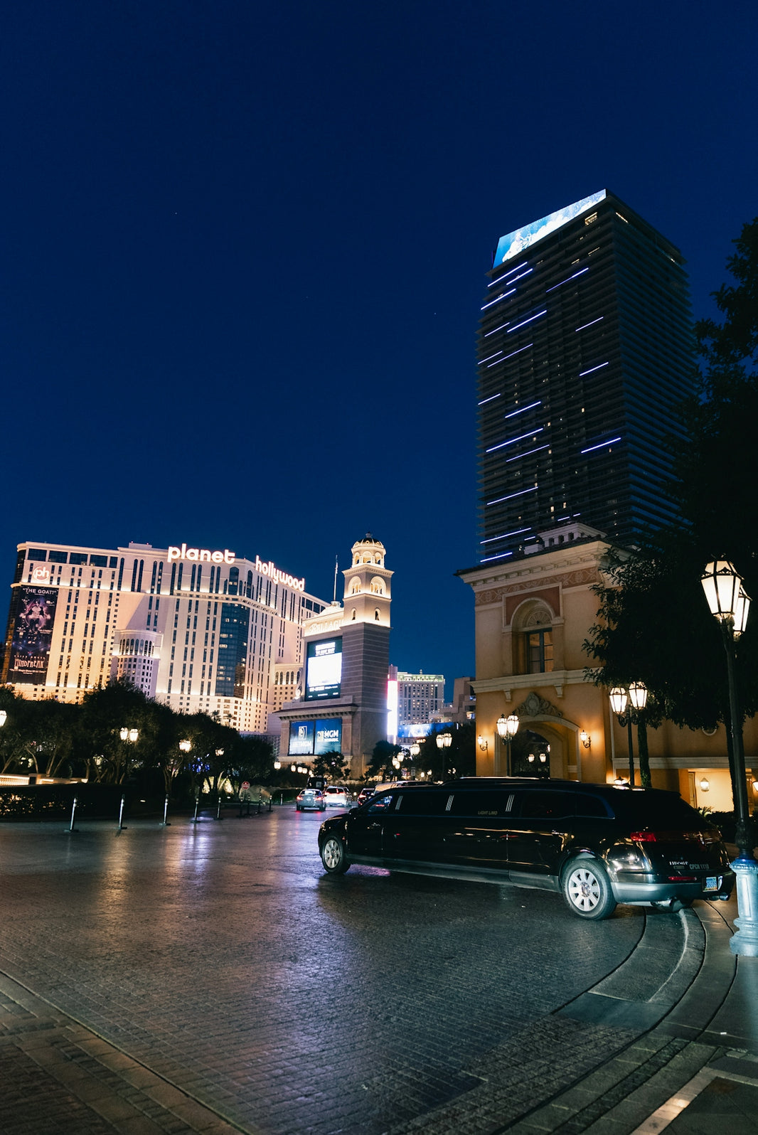 Limousine parked on wet street in city at night