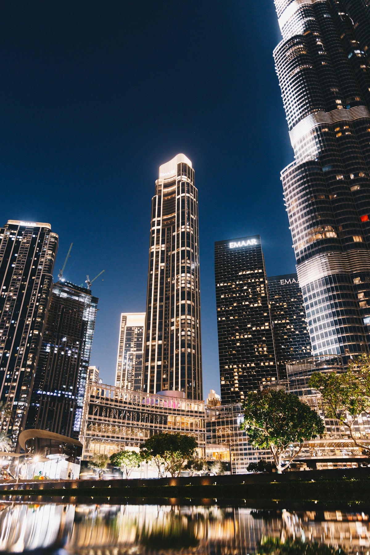 Modern skyscrapers illuminated at night with reflections in water