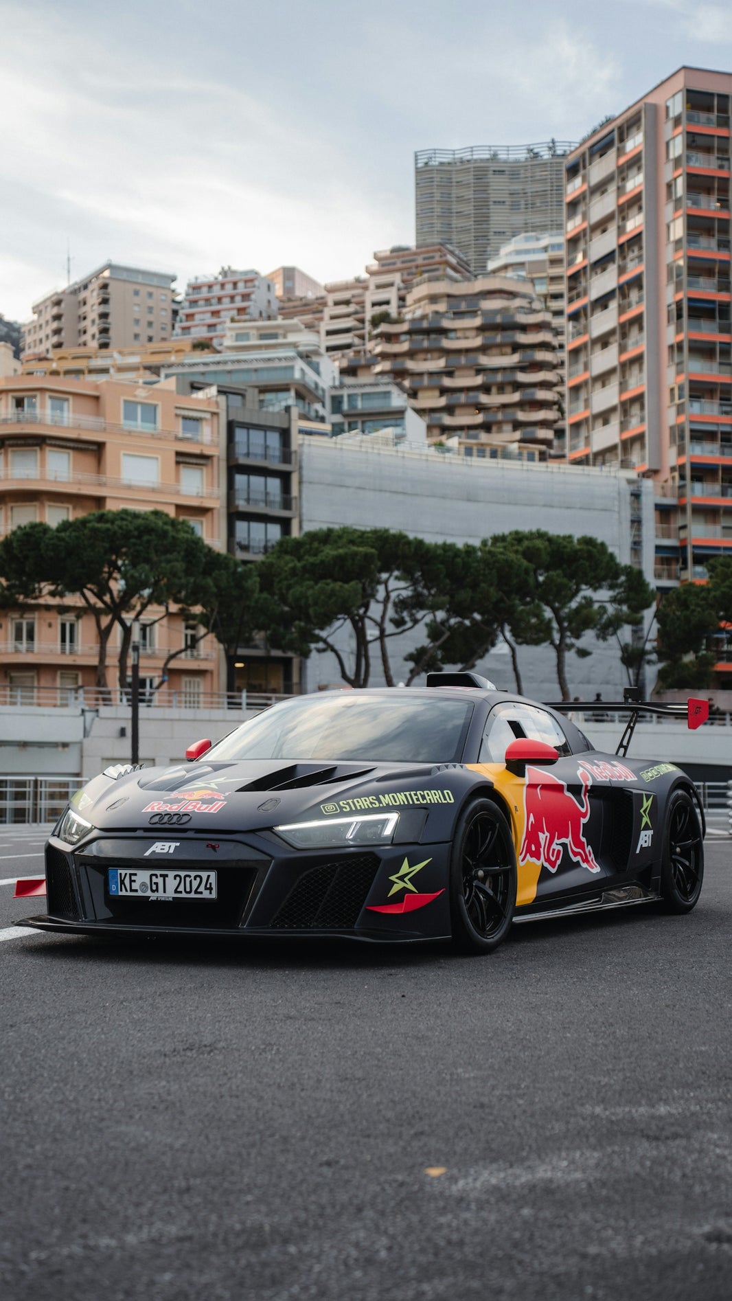 A race car with red bull branding on a street.