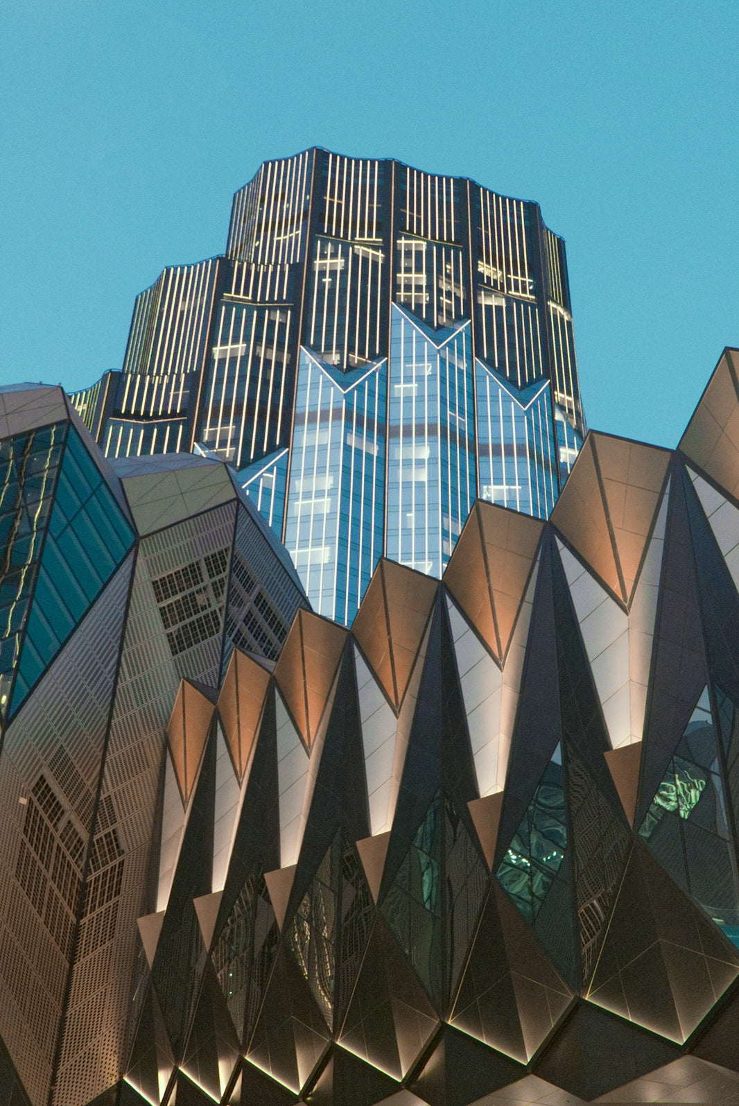 Modern geometric buildings against a clear blue sky.
