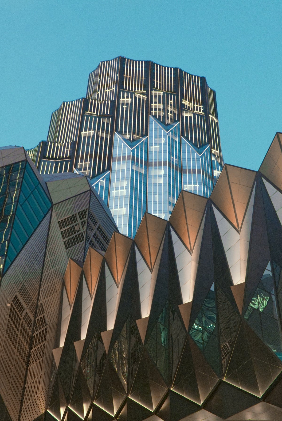 Modern geometric buildings against a clear blue sky.