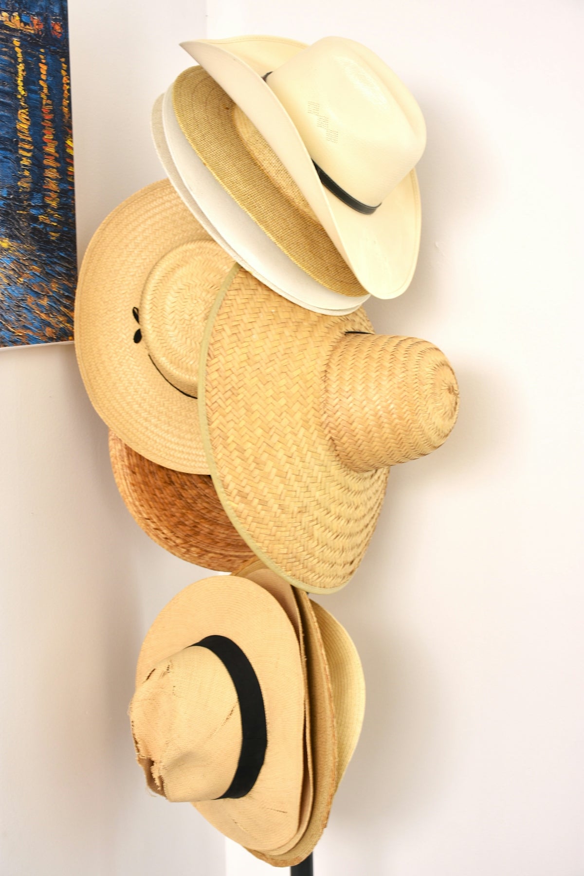 Several straw hats stacked vertically on a stand.