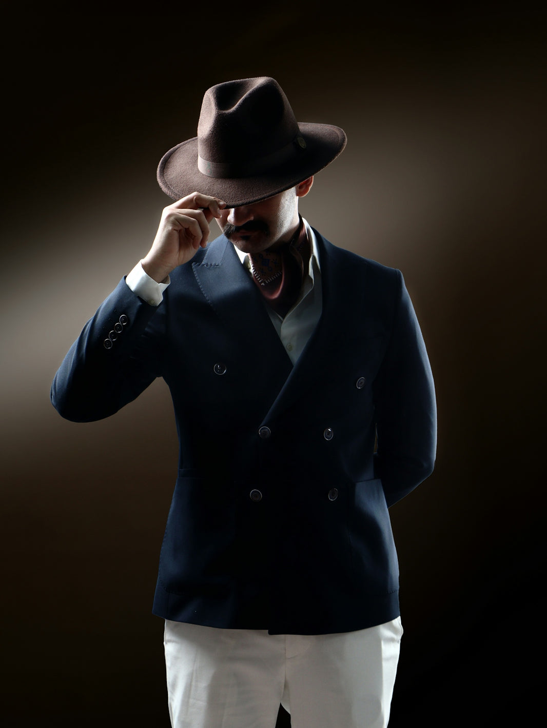 Man in fedora and suit tips hat dramatically.