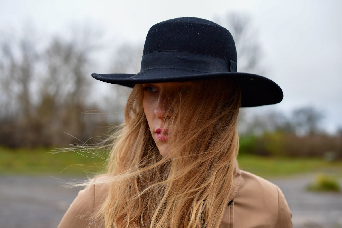 Woman with blonde hair wearing a black hat