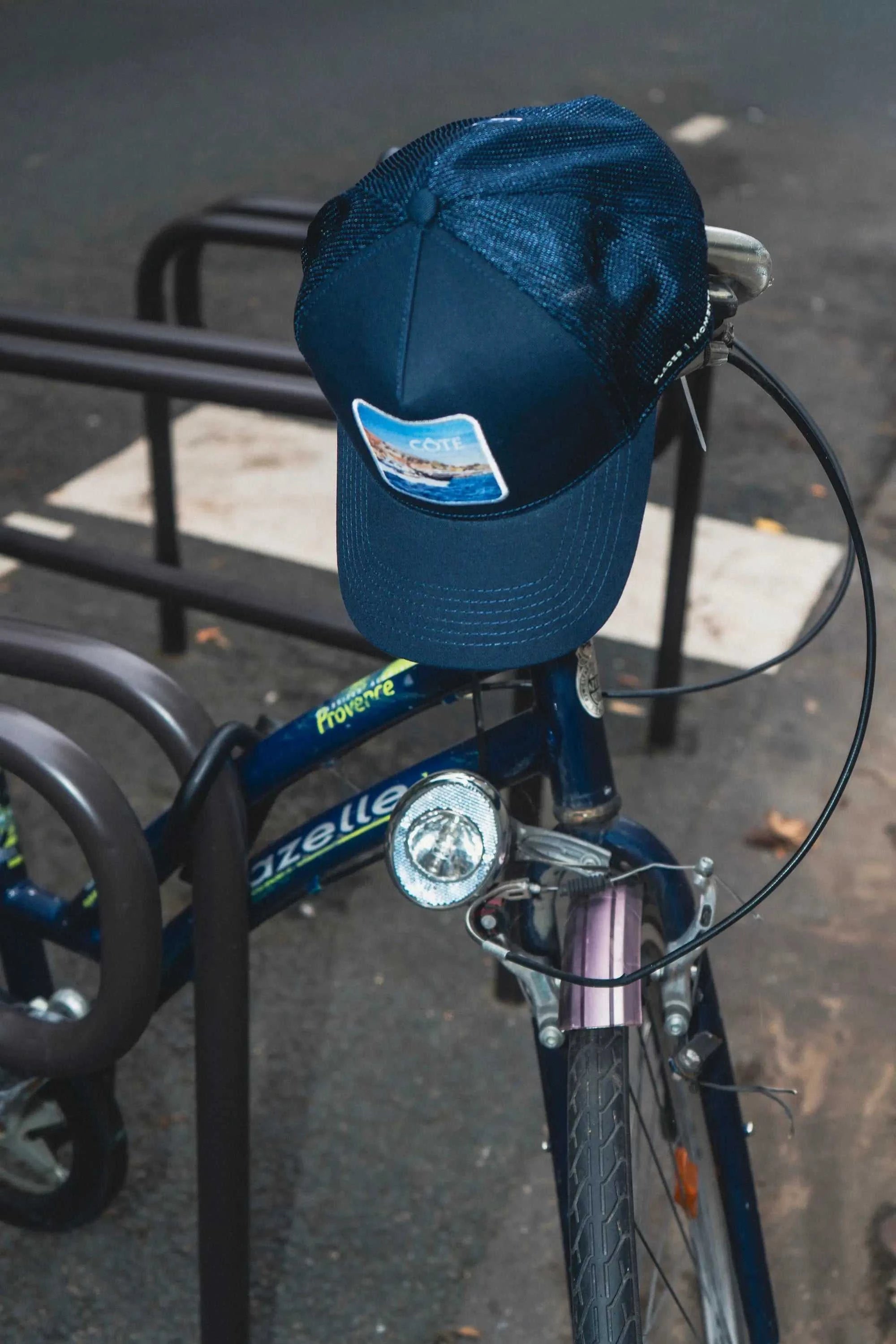 Côte Mesh-Back Trucker Hat in Indie Blue with structured front and breathable mesh back on bike handlebar