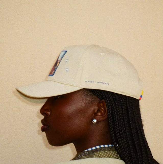Side and back view of the tan Paso Fino baseball cap with royal blue details and a small Colombian flag at the back.