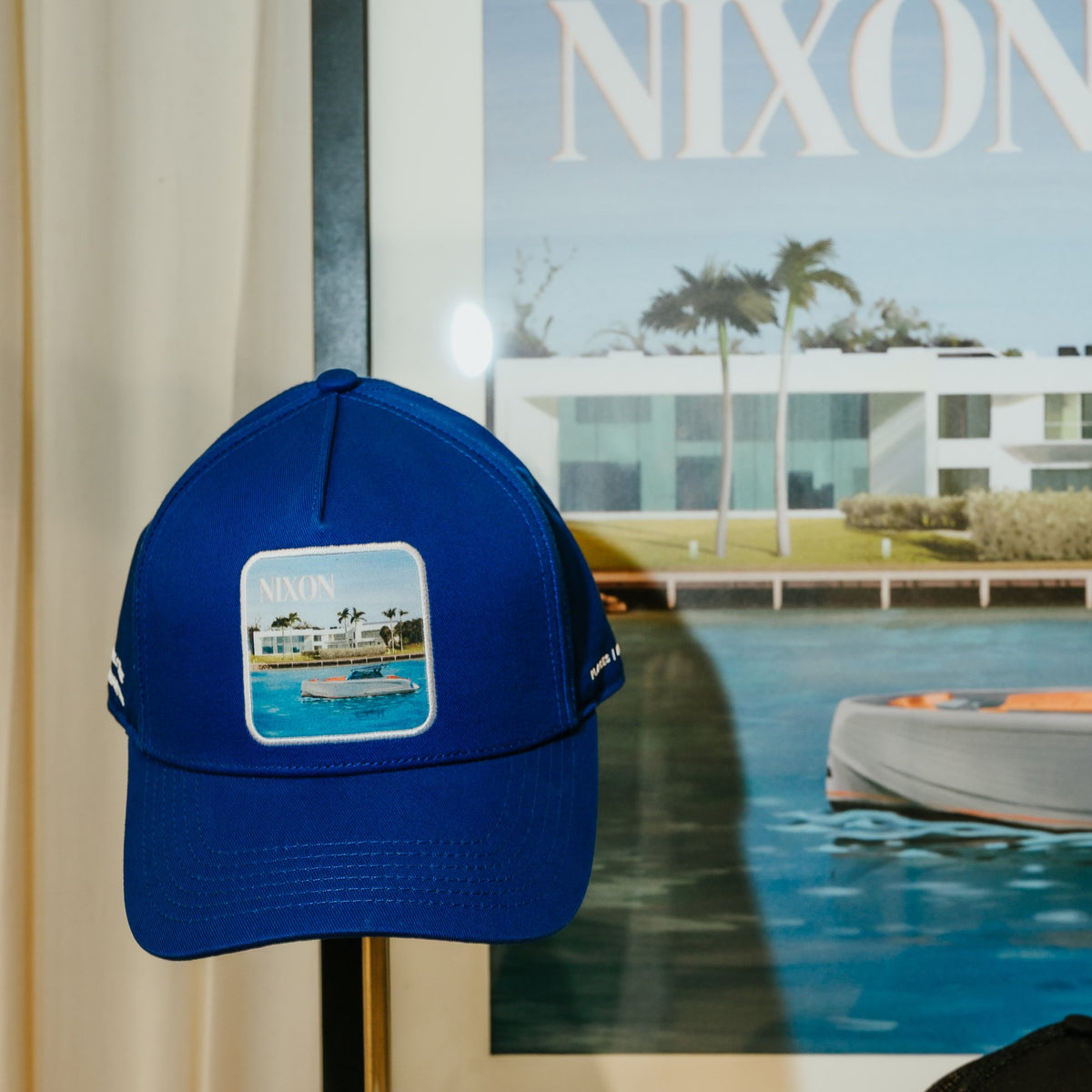 A framed print of the Nixon painting beside the Nixon cap