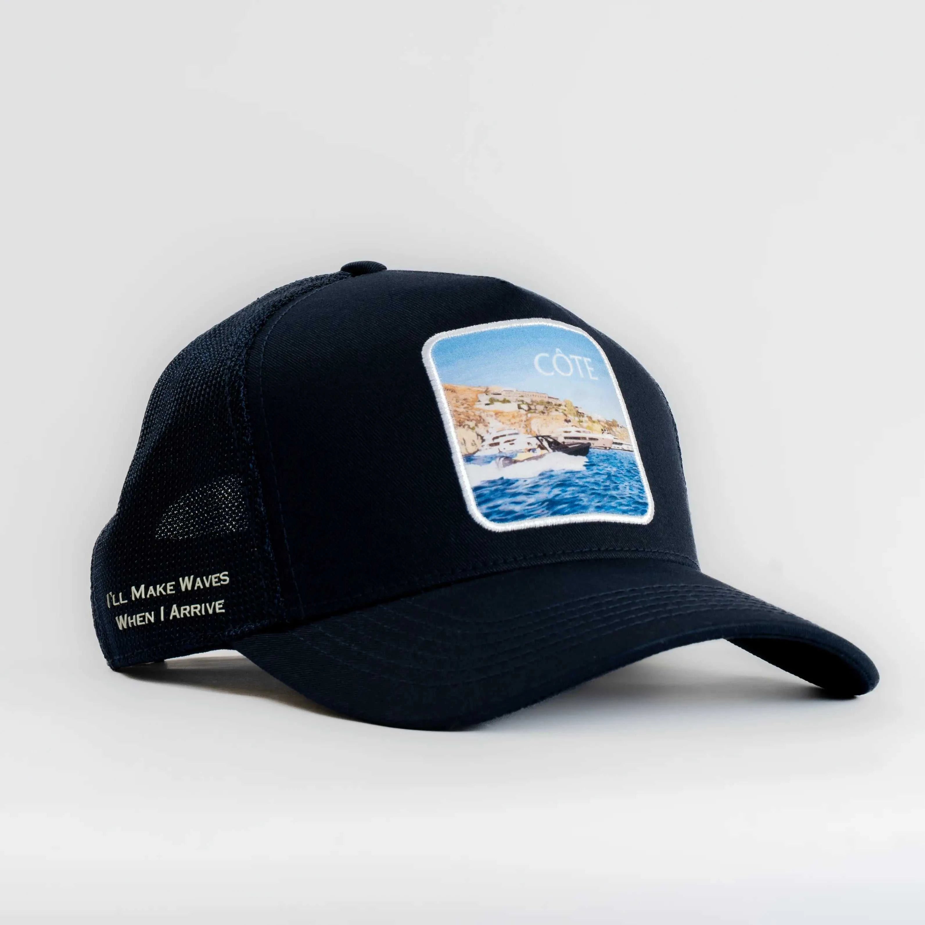 Côte Mesh-Back Trucker Hat in Indie Blue with structured front, breathable mesh back, curved brim, and coastal patch design