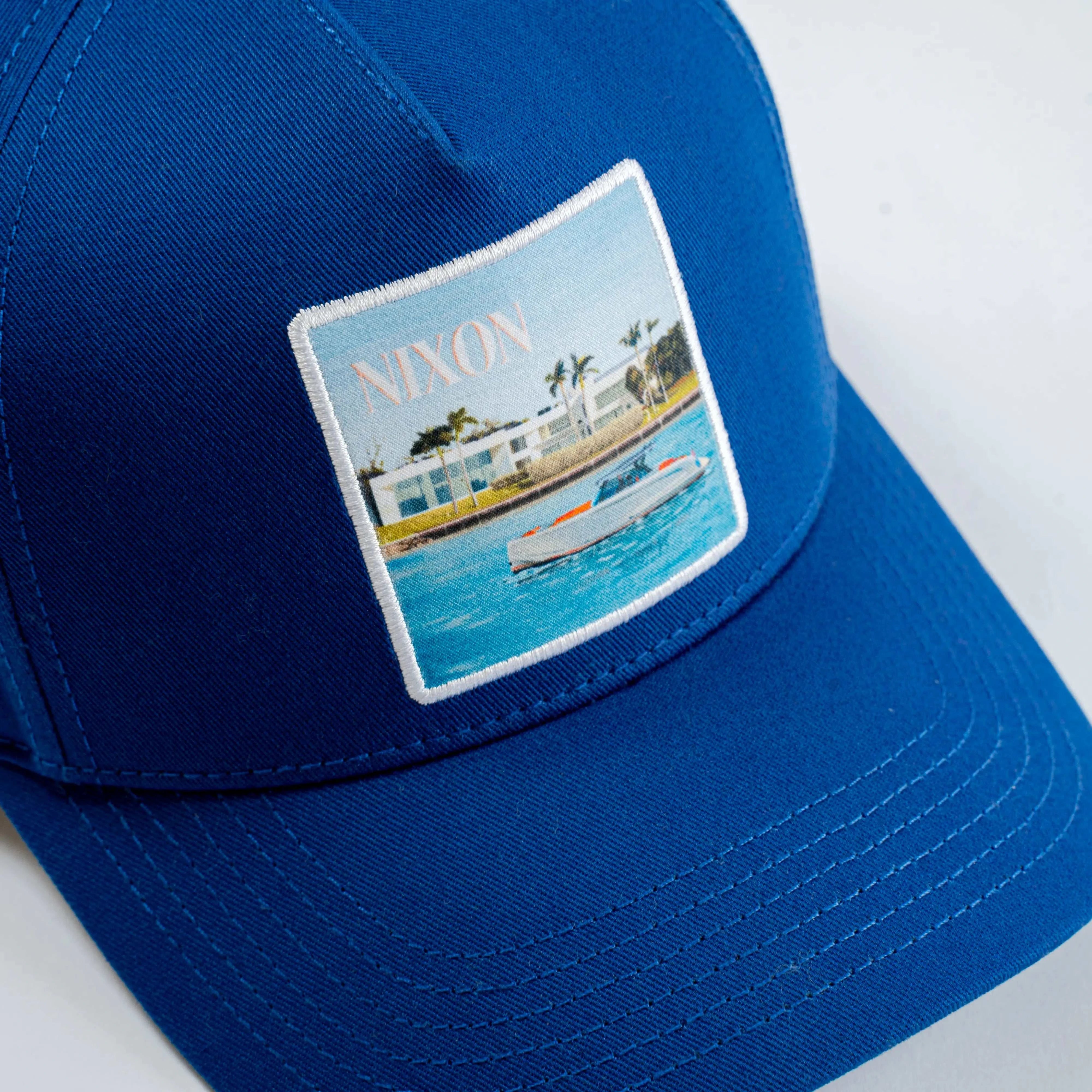 Blue Nixon Baseball Cap with ocean scene patch and curved brim for versatile everyday wear