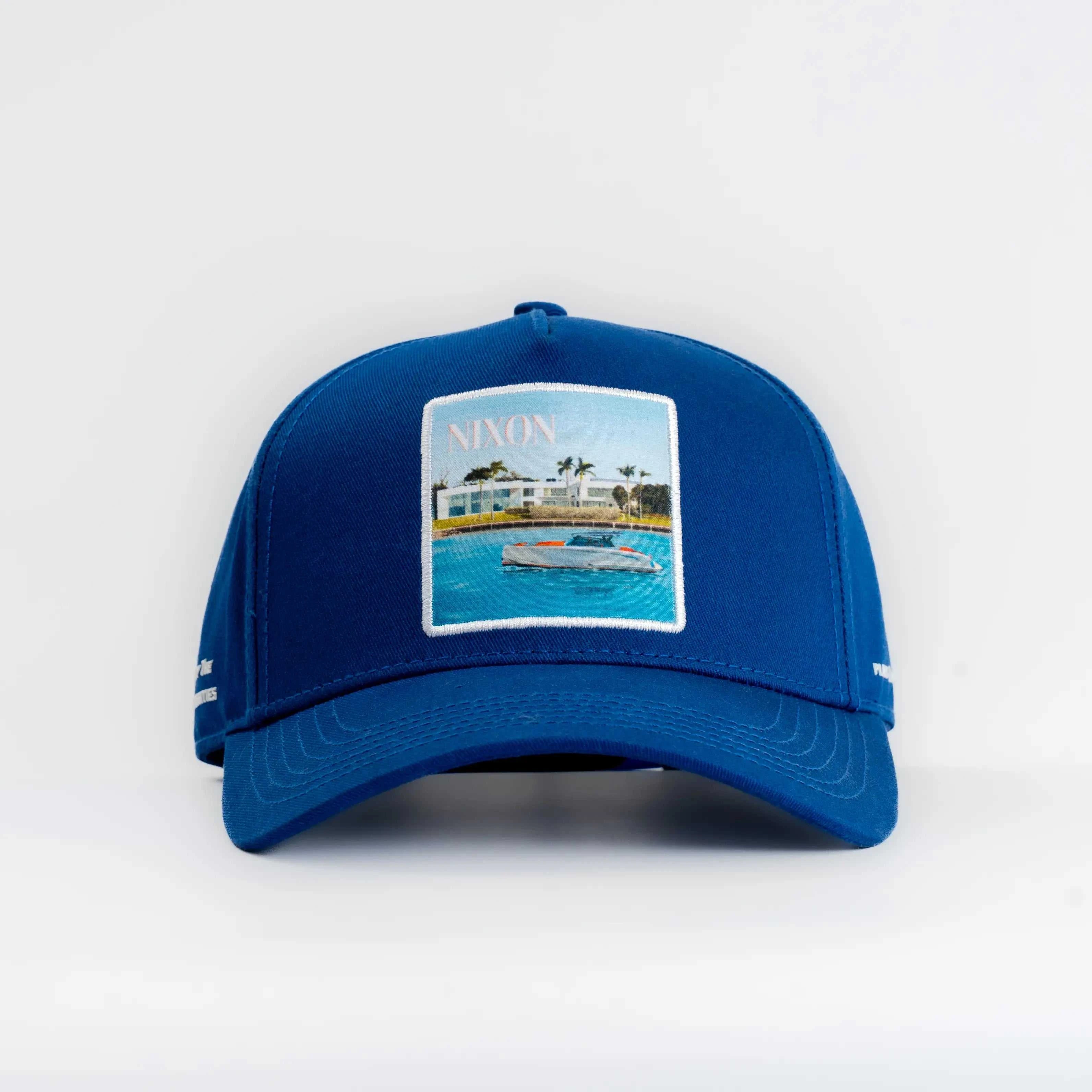 Blue Nixon Baseball Cap with coastal patch and curved brim.