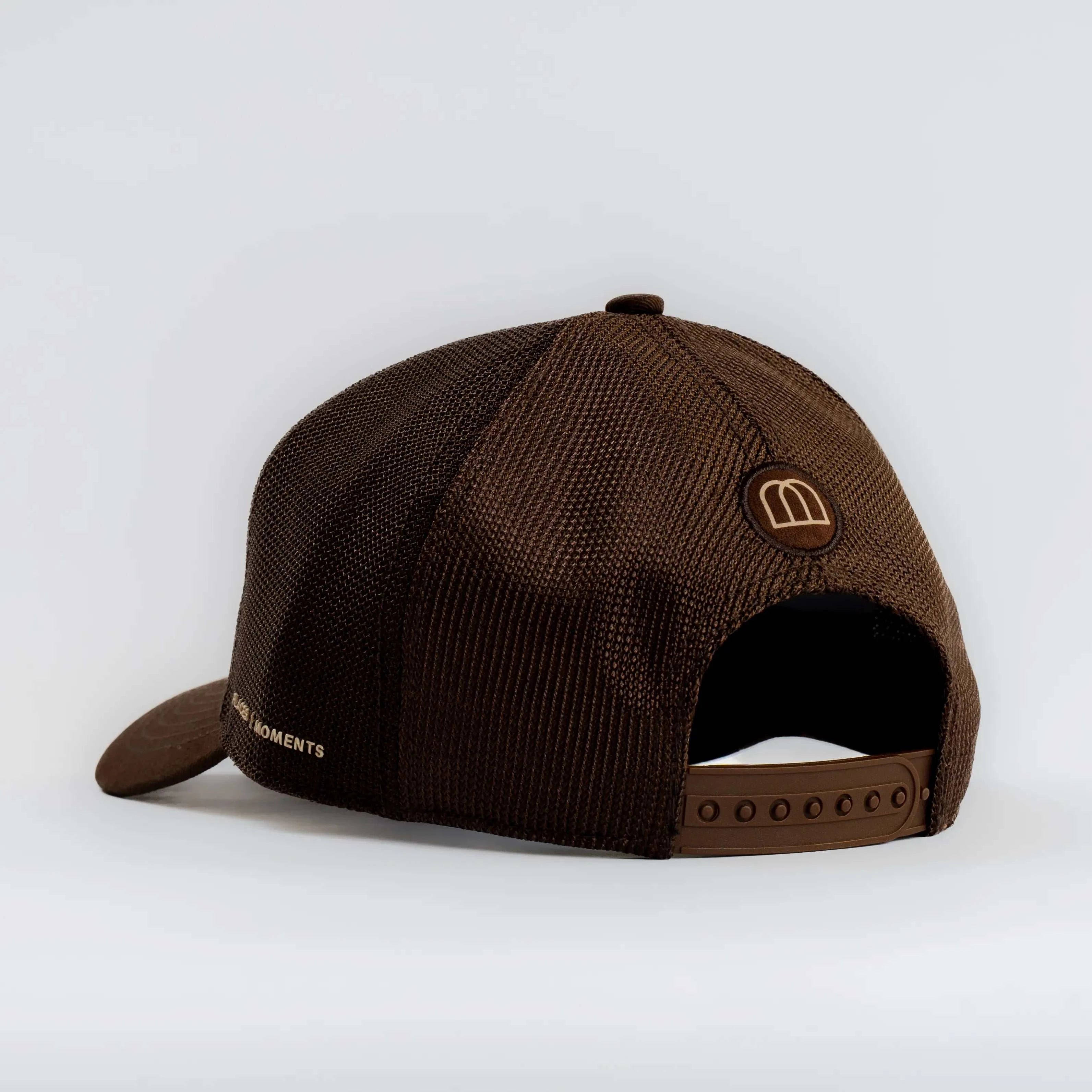 Brown Ovals Mesh-Back Trucker Hat with tan mesh back and adjustable strap, featuring embroidered logo patch and curved brim