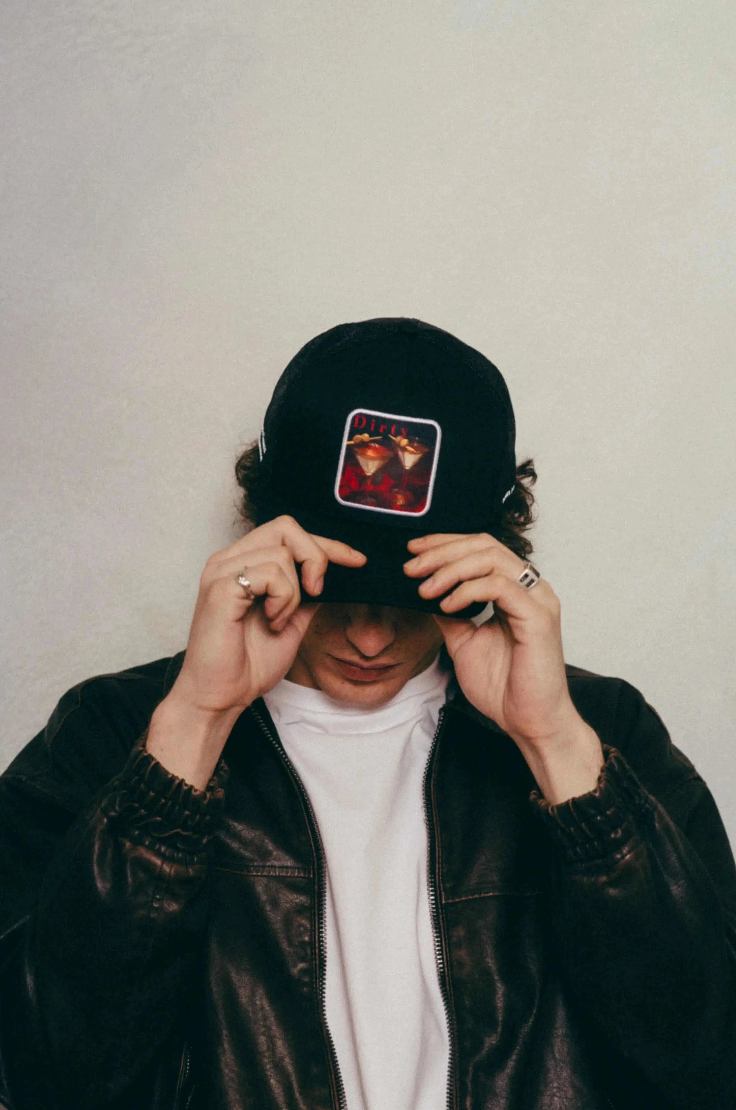 Man wearing black Dirty Martini Trucker Hat with mesh back and patch logo