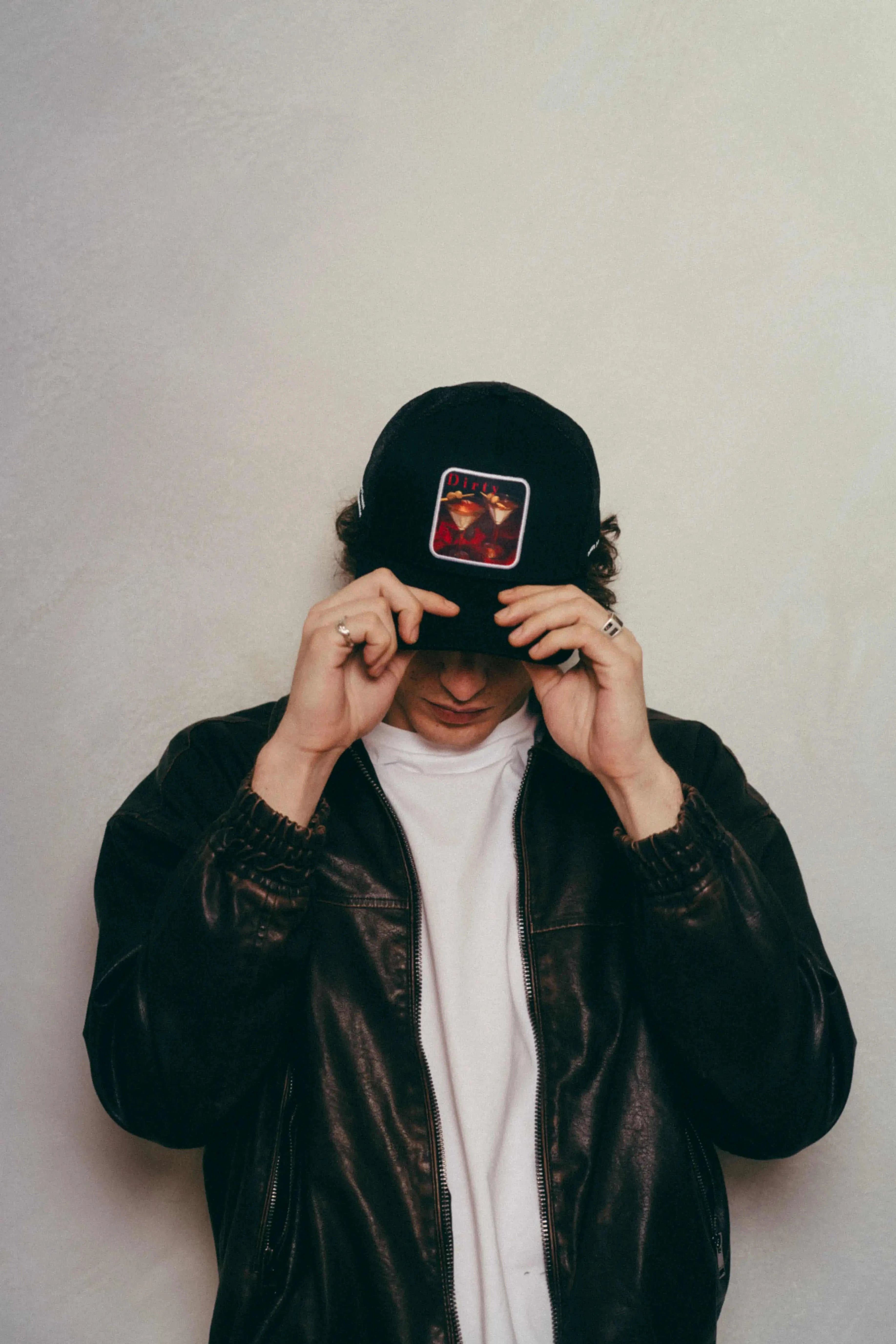 Man wearing black Dirty Martini Trucker Hat with mesh back and patch logo