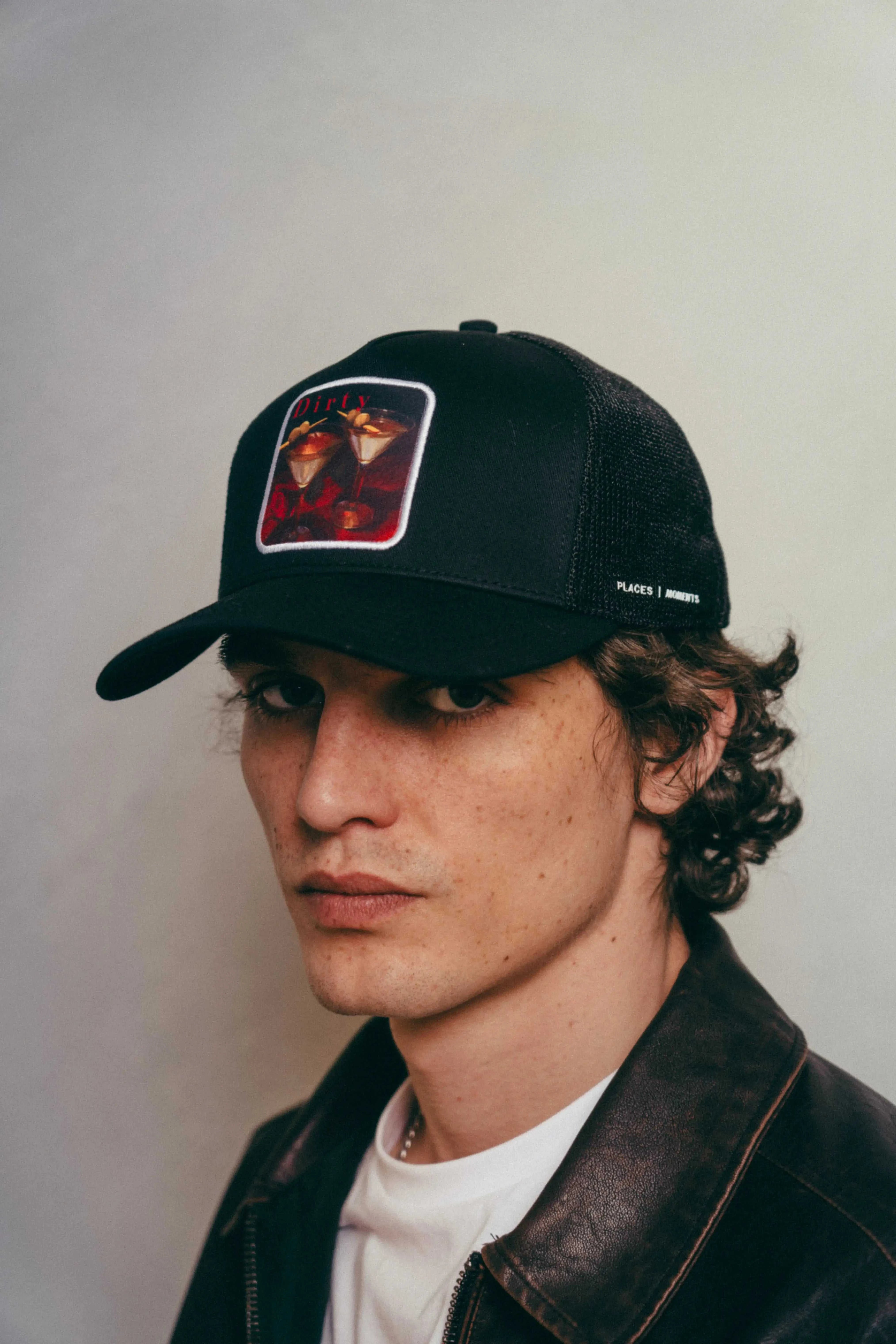 Man wearing black Dirty Martini Trucker Hat with mesh back and patch logo