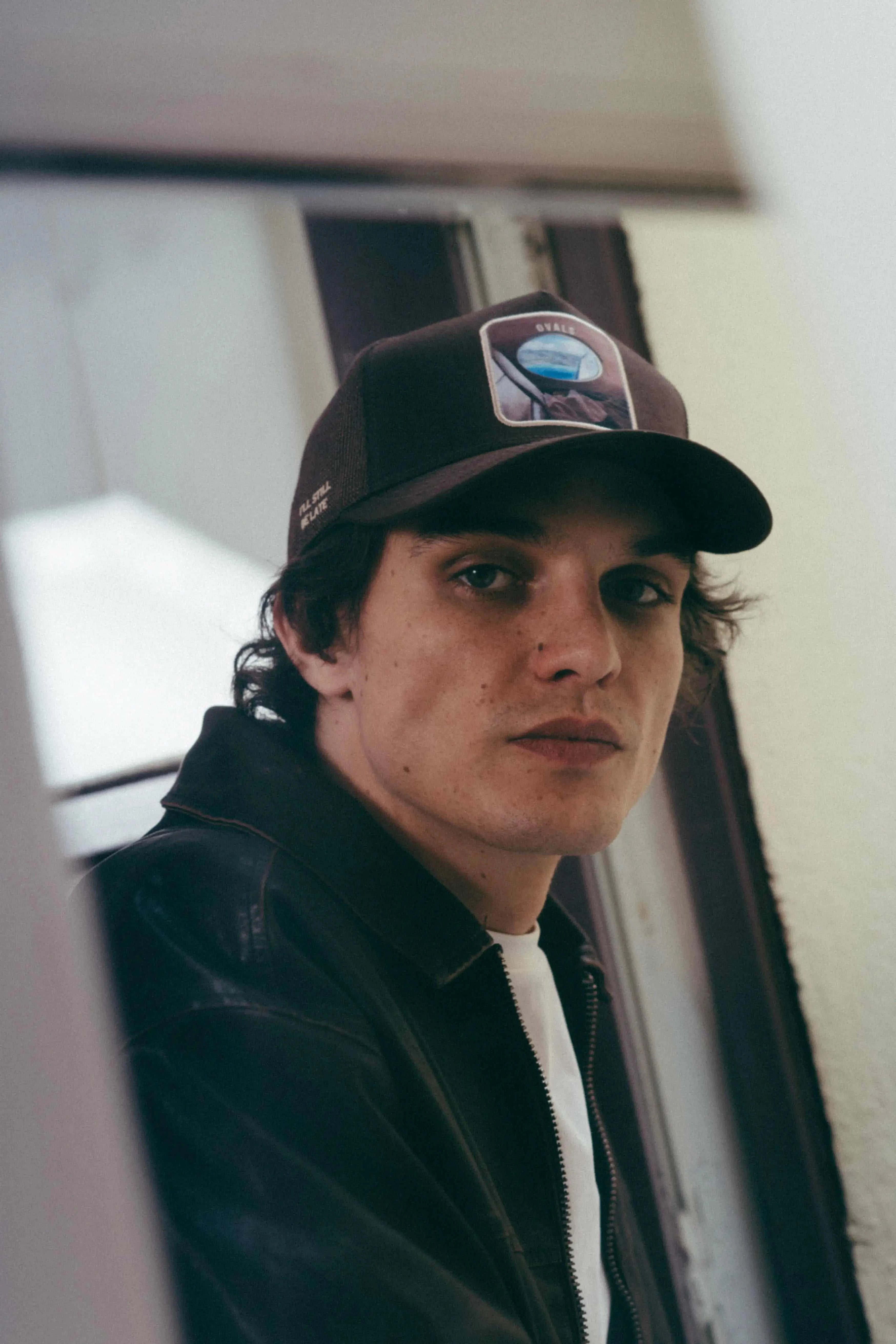 man wearing Ovals Mesh-Back Trucker Hat with embroidered patch and curved brim