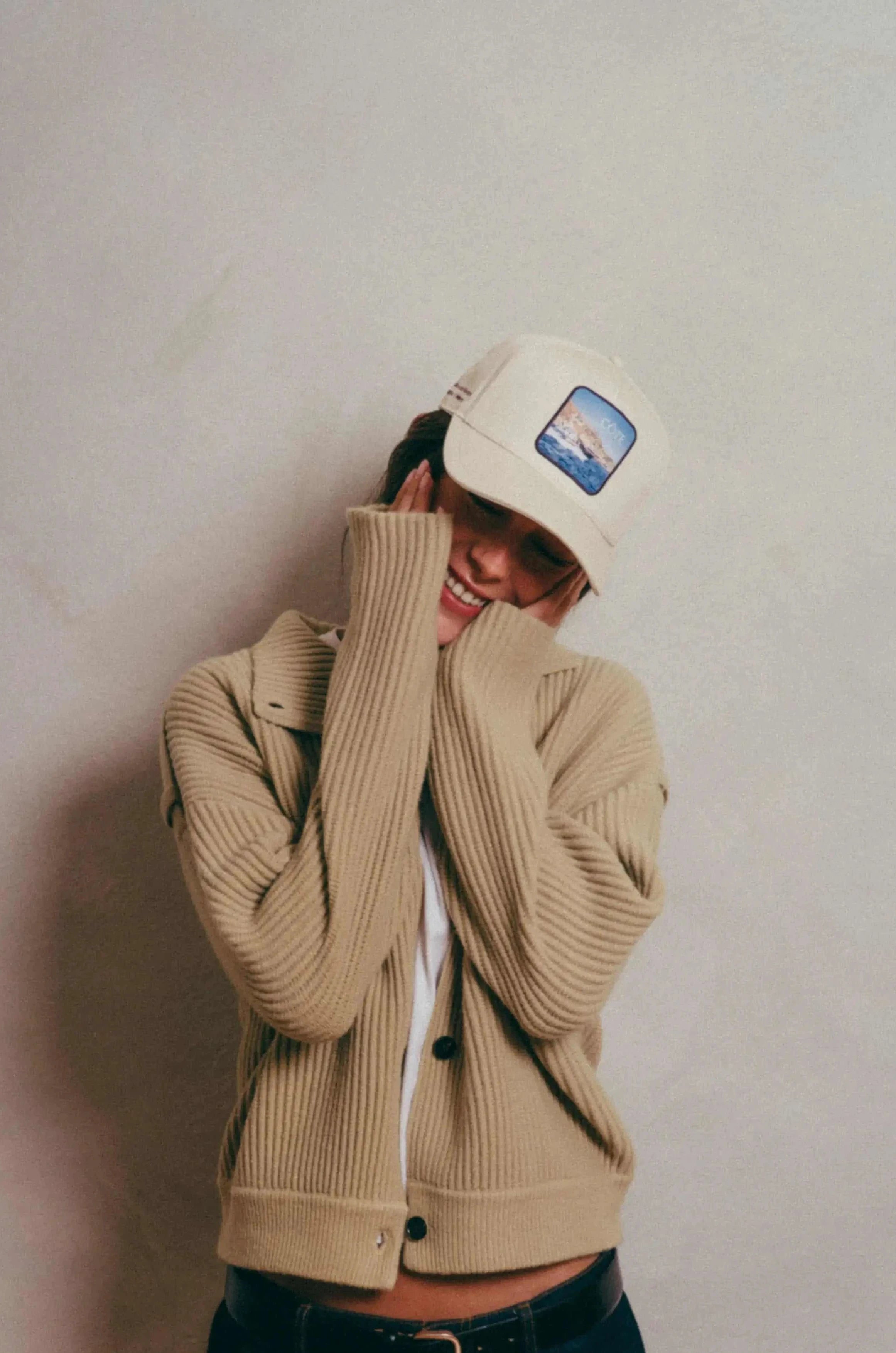 Côte Baseball Cap in Isla Crema worn with beige cardigan and dark jeans against neutral background