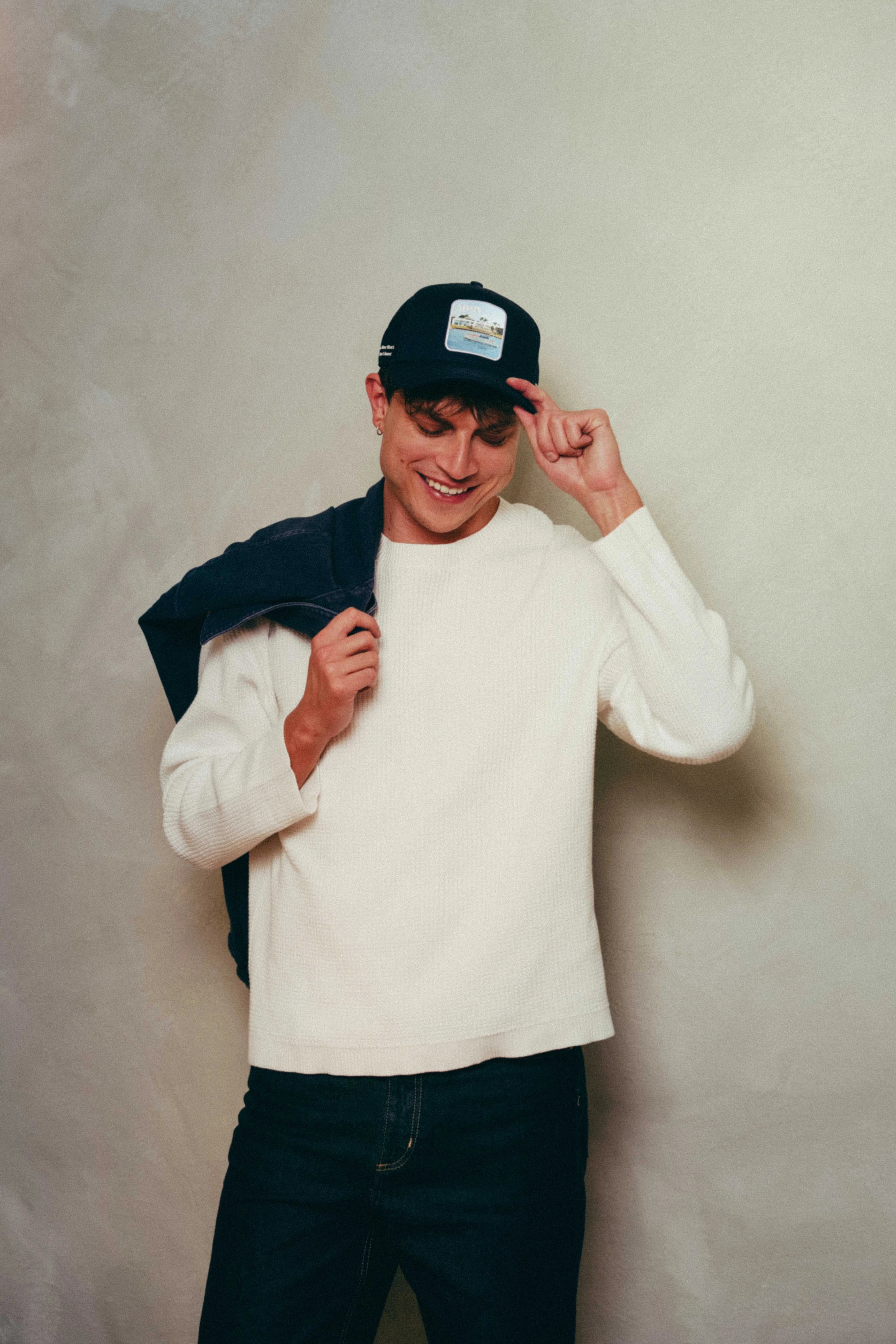 Black Nixon Mesh-Back Trucker Hat with structured front, breathable mesh, and embroidered patch worn by smiling man in casual outfit