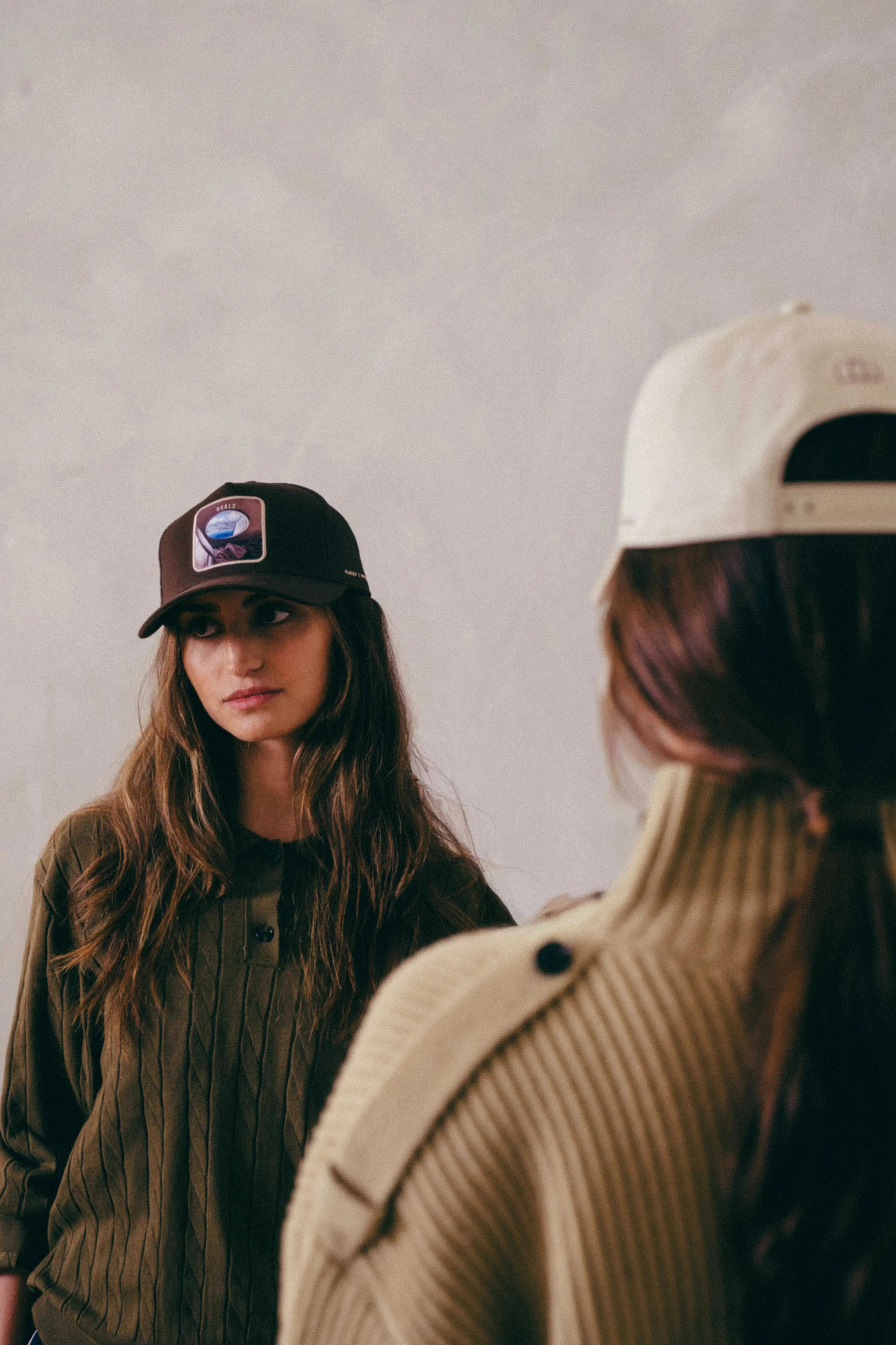 Brown Ovals Mesh-Back Trucker Hat with chestnut front panel and tan mesh back worn by a woman