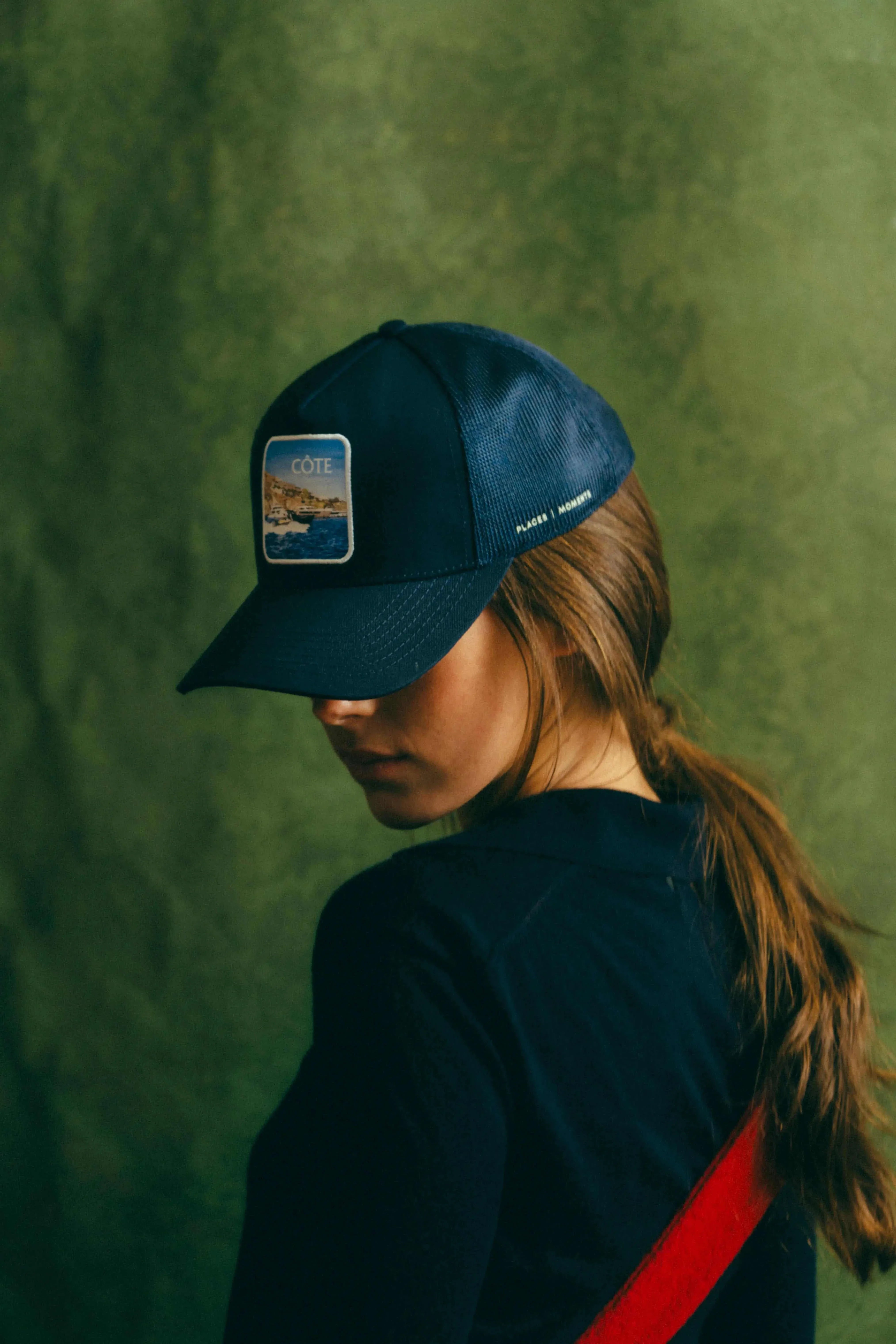 Côte Mesh-Back Trucker Hat in Indie Blue with structured front, breathable mesh, and curved brim worn by woman with ponytail