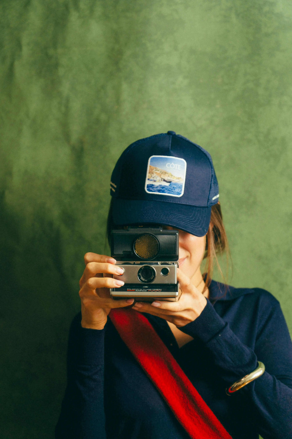 Côte Mesh-Back Trucker Hat in Indie Blue with structured front and breathable mesh back worn by person holding vintage camera