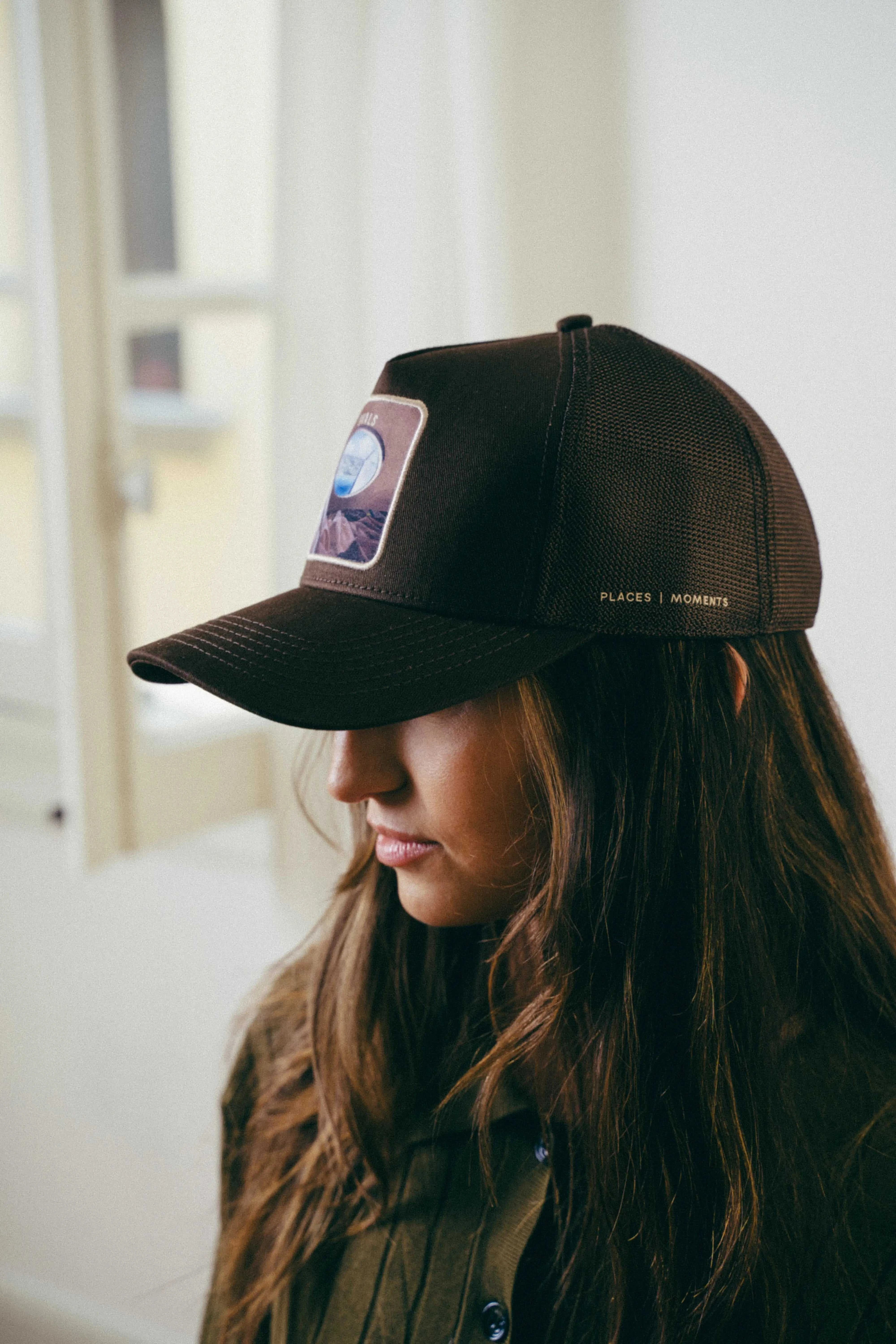 Ovals Mesh-Back Trucker Hat in chestnut with tan mesh back and embroidered patch worn by woman indoors
