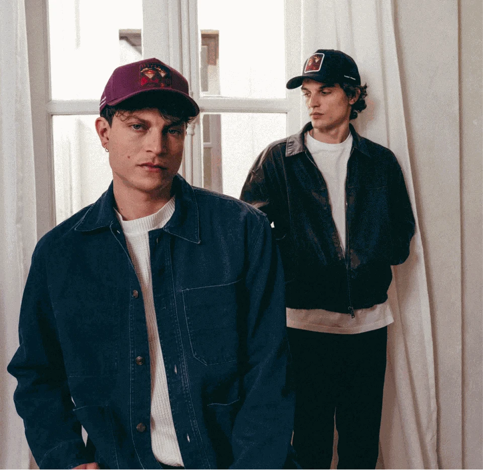 Two men indoors wearing Dirty Martini Baseball Caps in Indian Creek Red and black with logo patches